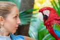 Face portrait of young girl looking at red macaw parrot Royalty Free Stock Photo