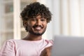 A face of positive smiling mestizo guy in joyful and happy mood. A young charming african or american man eats apple