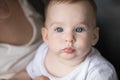 Face of pretty adorable blue eyed baby held by mom Royalty Free Stock Photo