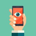 Face recognition, surveillance concepts. Hand holding smartphone with watching eye on screen. Mobile phone with eye icon. Modern f Royalty Free Stock Photo