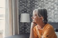 Face of senior caucasian hoary woman looking away deep in sad thoughts feels lonely close up portrait, recollect memories and life