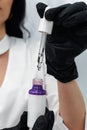 Face serum pipette close-up in hands of Cosmetologist. Cosmetology and pharmaceuticals concept