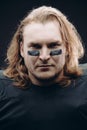 Determined American football player posing with painted face and chewing gum Royalty Free Stock Photo