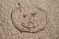 A face sketched on the sand. Children's drawing drawn with a stick on a wooded road Royalty Free Stock Photo