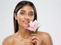 Face Skin Care. Beauty Indian Model smelling Lotus Flower. Beautiful Woman Portrait with Natural Make up and smooth Skin Royalty Free Stock Photo