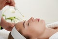 Face Skin Care. Closeup Of Beautiful Smiling Woman Receiving Serum Oil Treatment In Beauty Salon. Cosmetologist Applying Royalty Free Stock Photo