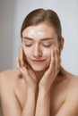 Face skin care. Woman applying facial cleanser on face closeup Royalty Free Stock Photo