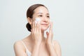 Face skin care. Woman applying facial cleanser on face closeup. Girl using cleansing cosmetic product on skin, washing face on Royalty Free Stock Photo