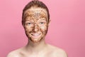 Face Skin Scrub. Portrait Of Smiling Female Model Applying Natural Coffee Mask, Face Scrub On Facial Skin. Closeup Royalty Free Stock Photo