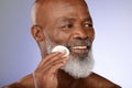 Face, skincare and antiaging with a senior black man exfoliating his skin in studio on a gray background. Beauty Royalty Free Stock Photo