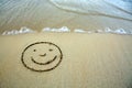 Face smail drawing in the sand at the caribbean beach. Royalty Free Stock Photo