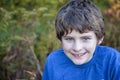 Face of a smiling nine year old boy with blue eyes outside Royalty Free Stock Photo