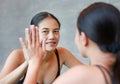 Face of smiling young asian woman looking at her reflection in mirror Royalty Free Stock Photo