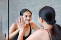 Face of smiling young asian woman looking at her reflection in mirror to camera Royalty Free Stock Photo