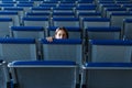 Face of a teenage girl at the empty waiting hall of an airport sitting alone on blue chairs Royalty Free Stock Photo