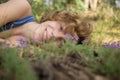 Face of teenage girl lying on grass with small flowers, enjoying nature Royalty Free Stock Photo