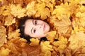 Face of teenage girl under maple leaves