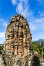 Face tower in the Bayon temple in Angkor over blue sky. Cambodia. Vertical view Royalty Free Stock Photo