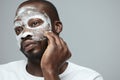 Face Treatment. Skin Care Procedure For Man. Model Applying White Facial Mask During Spa Relaxation. Royalty Free Stock Photo