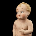 Face of vintage baby doll from ceramics closeup, isolated on black background Royalty Free Stock Photo