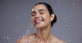 Face, water and woman with skincare, orange and smile with cosmetics, aesthetic and grooming on grey studio background