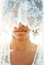 Face of a woman in a white dress is half hidden by a veil Royalty Free Stock Photo