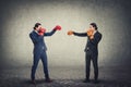 Face you own fears business metaphor as a businessman with boxing gloves confronts his office clone or copy. Fighting yourself,