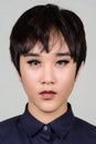 Face of young androgynous Asian transgender woman