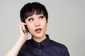 Face of young androgynous Asian transgender woman talking on the phone