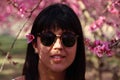 Face of young beautiful woman with pink flowers peach tree in her hair Royalty Free Stock Photo