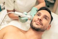 Young smiling man enjoying painless oxygen meso therapy