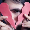 Face of young handsome man with broken paper heart Royalty Free Stock Photo