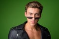 Face of young handsome rebellious man wearing leather jacket and sunglasses Royalty Free Stock Photo