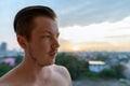 Face of young handsome shirtless man thinking against view of the city Royalty Free Stock Photo