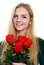 Face of young happy teenage girl smiling while holding red roses Royalty Free Stock Photo