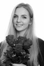 Face of young happy teenage girl smiling while holding roses ready for Valentine`s day Royalty Free Stock Photo