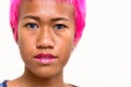 Face of young rebellious Asian woman with pink hair and nose piercing