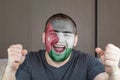 Face of young screaming man painted with flag of Jordan. Soccer team fan. Royalty Free Stock Photo