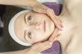 Face of young woman during procedure of applying cream. Healthy facial massage, lymphatic drainage massage. Top view