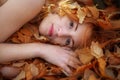 Face of a young woman among red golden foliage Royalty Free Stock Photo