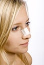 Face of young woman with sticking plaster on nose Royalty Free Stock Photo