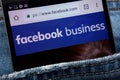 Facebook business website displayed on smartphone hidden in jeans pocket