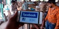 Facebook logo with like button displayed on smart phone screen at farmers market