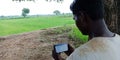 Facebook page displayed on smart phone screen by indian villager at agriculture produce land