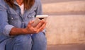 Woman sitting in the park using her mobile phone.