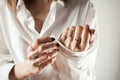 Faceless closeup portrait of white woman buttoning her white shirt