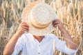 Faceless. cute kid boy covers his face straw hat  on wheat field.  A child walks outside in the countryside. Lifestyle Royalty Free Stock Photo