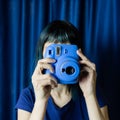 Faceless girl with a blue camera