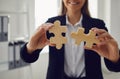 Faceless hands of a businesswoman with wooden puzzles in hands in the office.