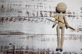 Faceless knitted human figure with knitting needle on wooden background